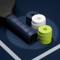 Three pickleball paddle overgrips in navy, white and green